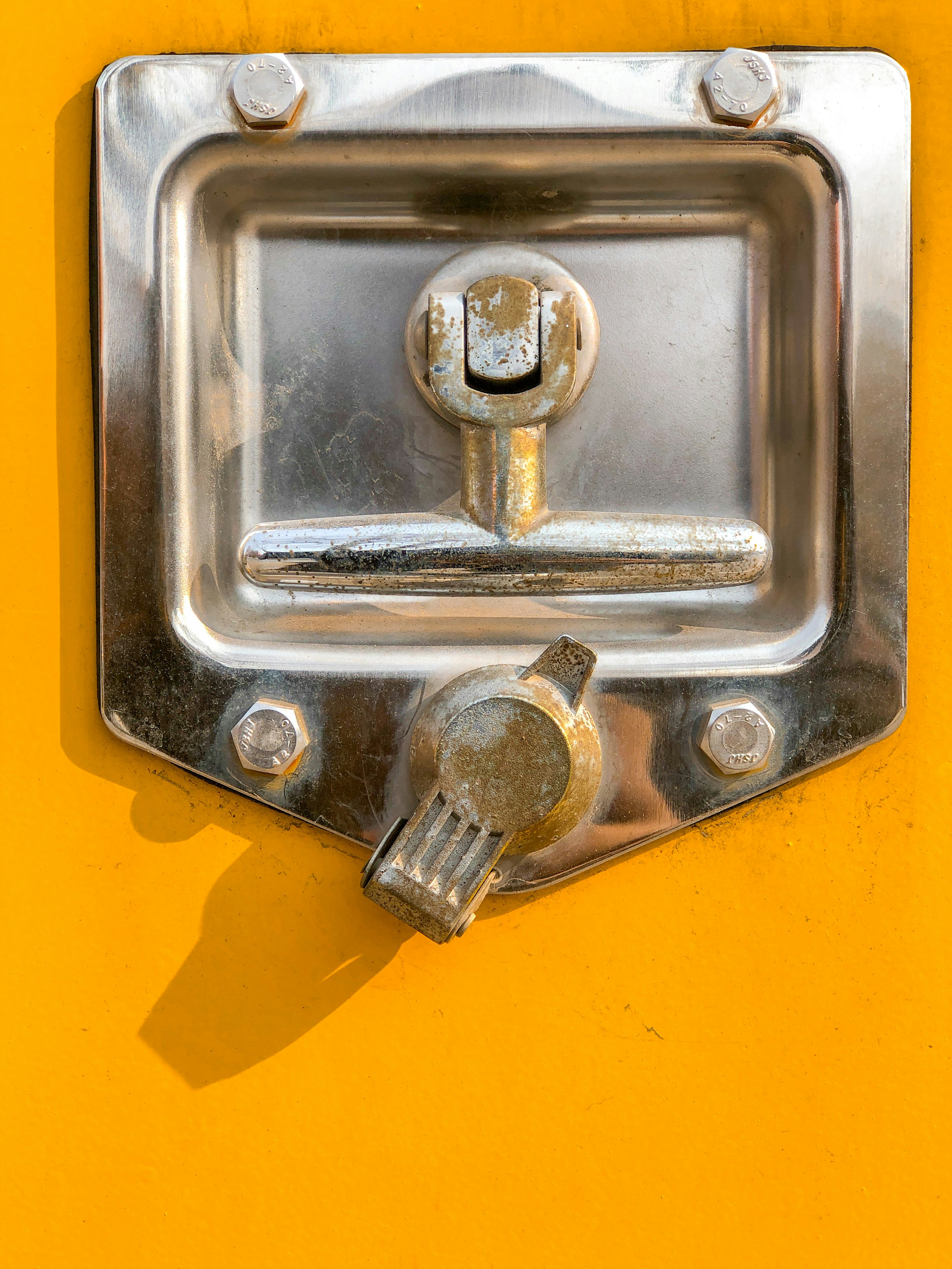 silver door knob on yellow door